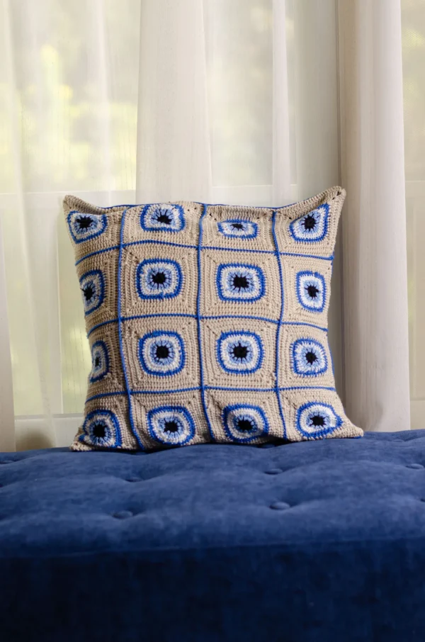 "Gaze into Serenity: Crochet Cushion with Blue Eyes"